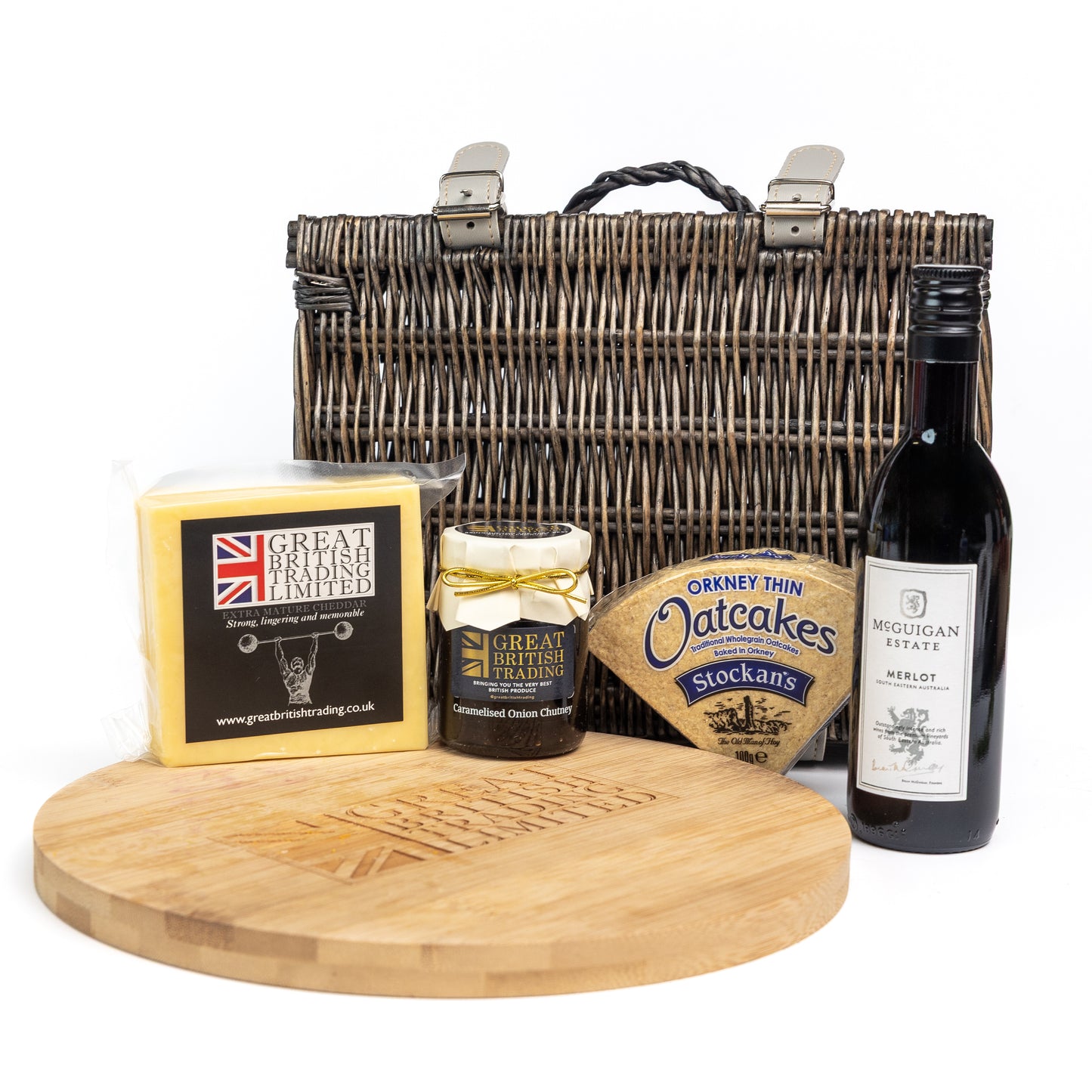 Gourmet gift set with a basket, cheese, jam, oatcakes, and wine on a white background